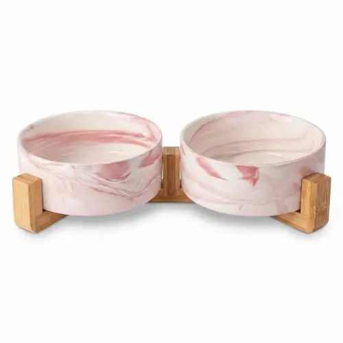 Two marble pink ceramic dog bowls on a natural wood stand