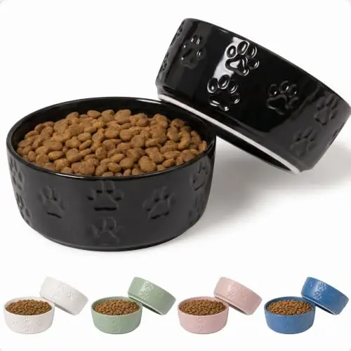 Two black ceramic dog bowls with allover paw print pattern and non‑skid bases